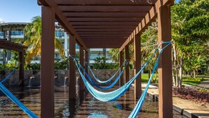A hammock under a wooden pergola over a water feature. - Casa Bellisima ! 2 bedroom swim up 2 Apts by RedAwning (Playa del Carmen)