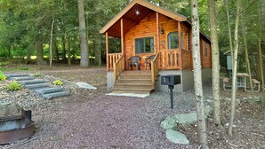 Une cabane en bois avec une véranda, des marches et une boîte aux lettres.