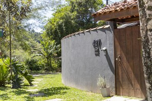 Un bâtiment avec une façade grise, une porte en bois et une petite plante en pot.