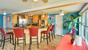 A kitchen with wooden cabinets, a central island with bar stools, and a ceiling fan. - Massachusetts Vacation Rental: 5 Mi to Fall River (Somerset)
