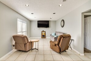 Relax in this spacious living area with a flat-screen TV and comfortable seating.
