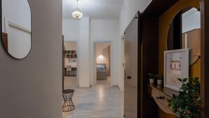 A hallway with a chandelier, a mirror, and a welcome sign. - La Casetta di Dado by Wonderful Italy (Turin)