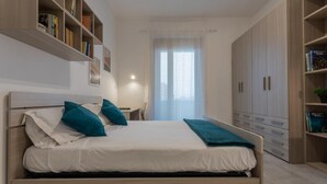 A neatly arranged bedroom with a bed, built-in shelving, and a large wardrobe. - La Casetta di Dado by Wonderful Italy (Turin)