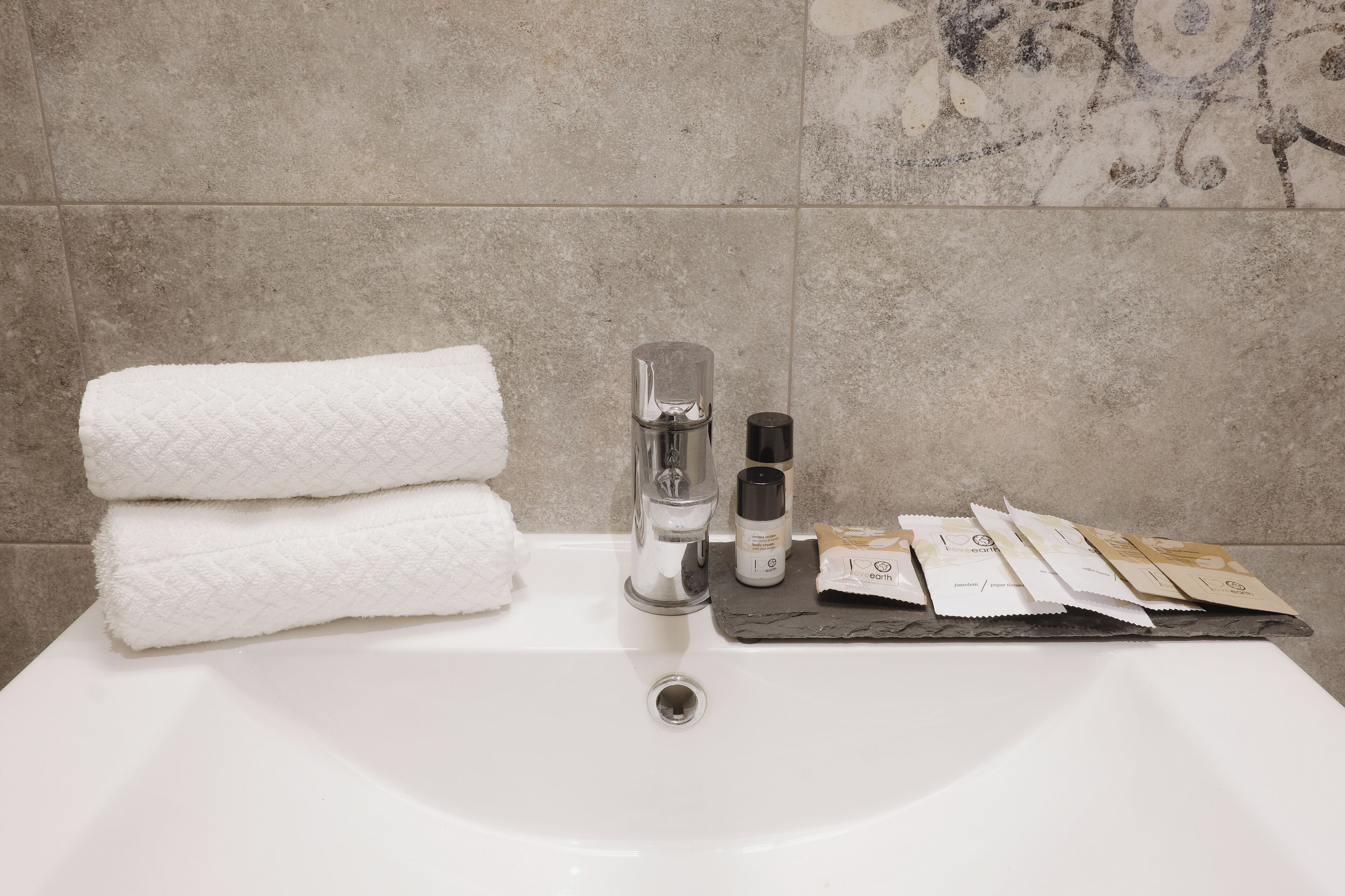 A bathroom sink with a white towel, a soap dispenser, and a soap bar.