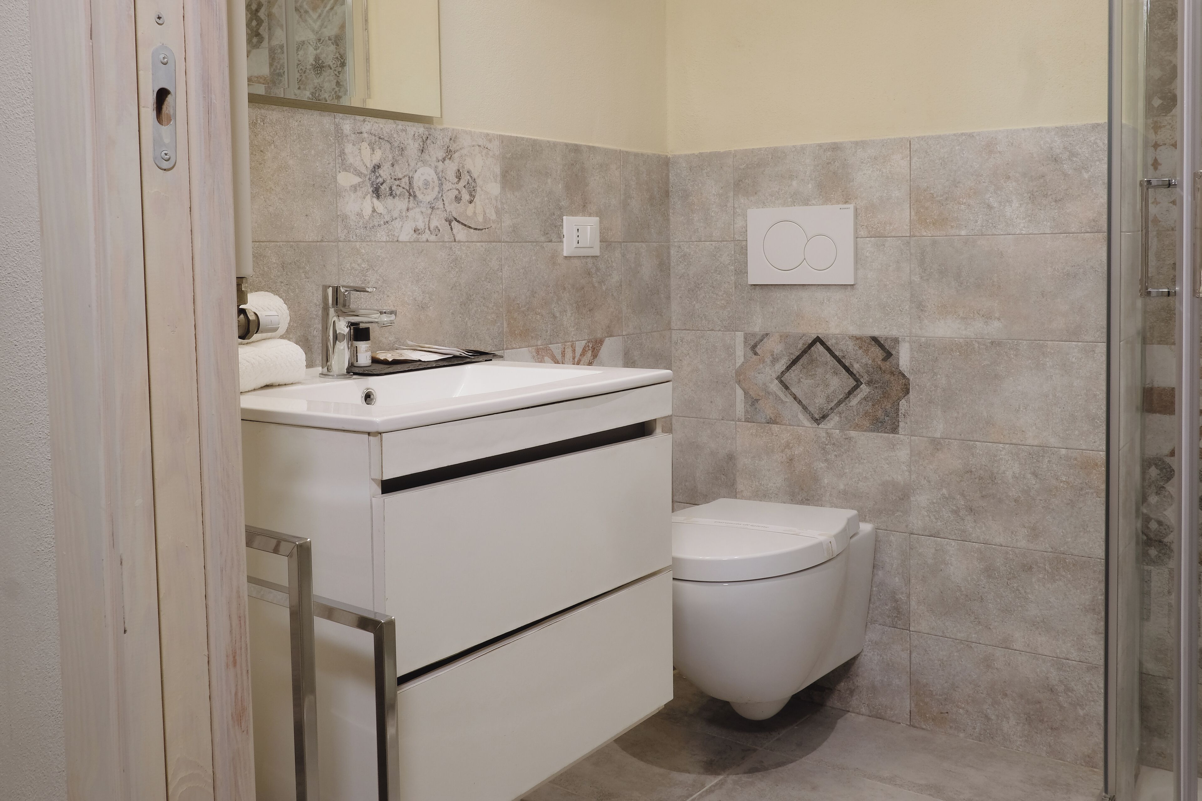 Ein modernes Badezimmer mit einem weißen Waschbecken, einer Toilette und einer Duschkabine.