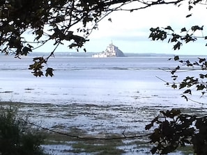 Une vue côtière avec un bâtiment situé sur une île, entouré d’eau.
