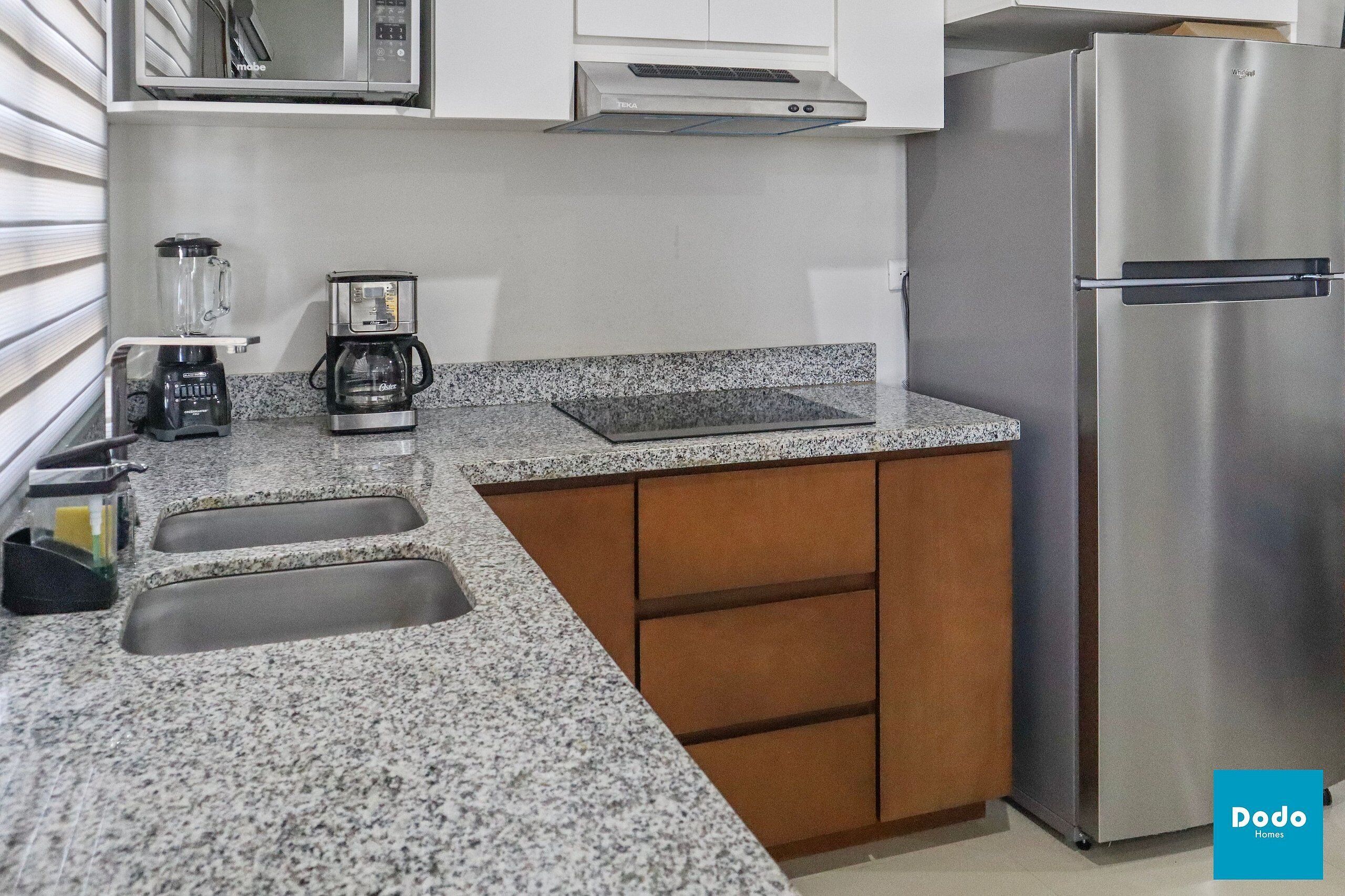A kitchen with granite countertops, stainless steel appliances, and wooden cabinets.