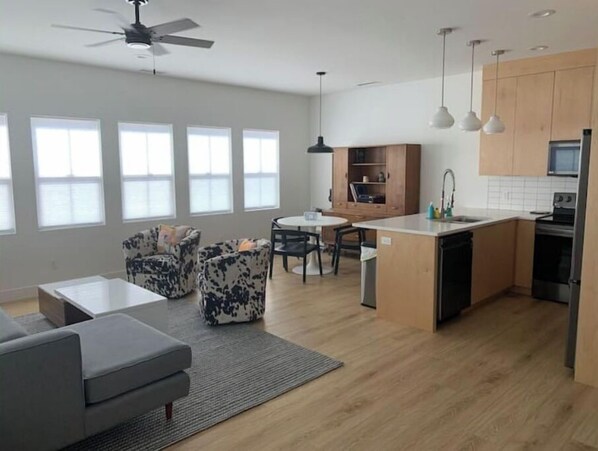 Enjoy a spacious living area with a kitchen, dining table, and comfortable sofa.