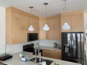 Enjoy cooking in this well-equipped kitchen with a stainless steel refrigerator, microwave, sink, and coffee maker.