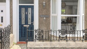 A townhouse with a blue front door, a bay window, and a stone facade. - Maes Y Ddol (Pwllheli)