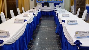 A conference room with a long table, nameplates, and a banner. - HOTEL MAVILLA Cotonou (Cotonou)