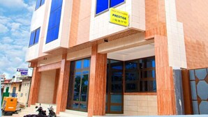 A multi-story building with a modern design, featuring large windows and a prominent yellow sign indicating a business or service on the ground floor. - HOTEL MAVILLA Cotonou (Cotonou)