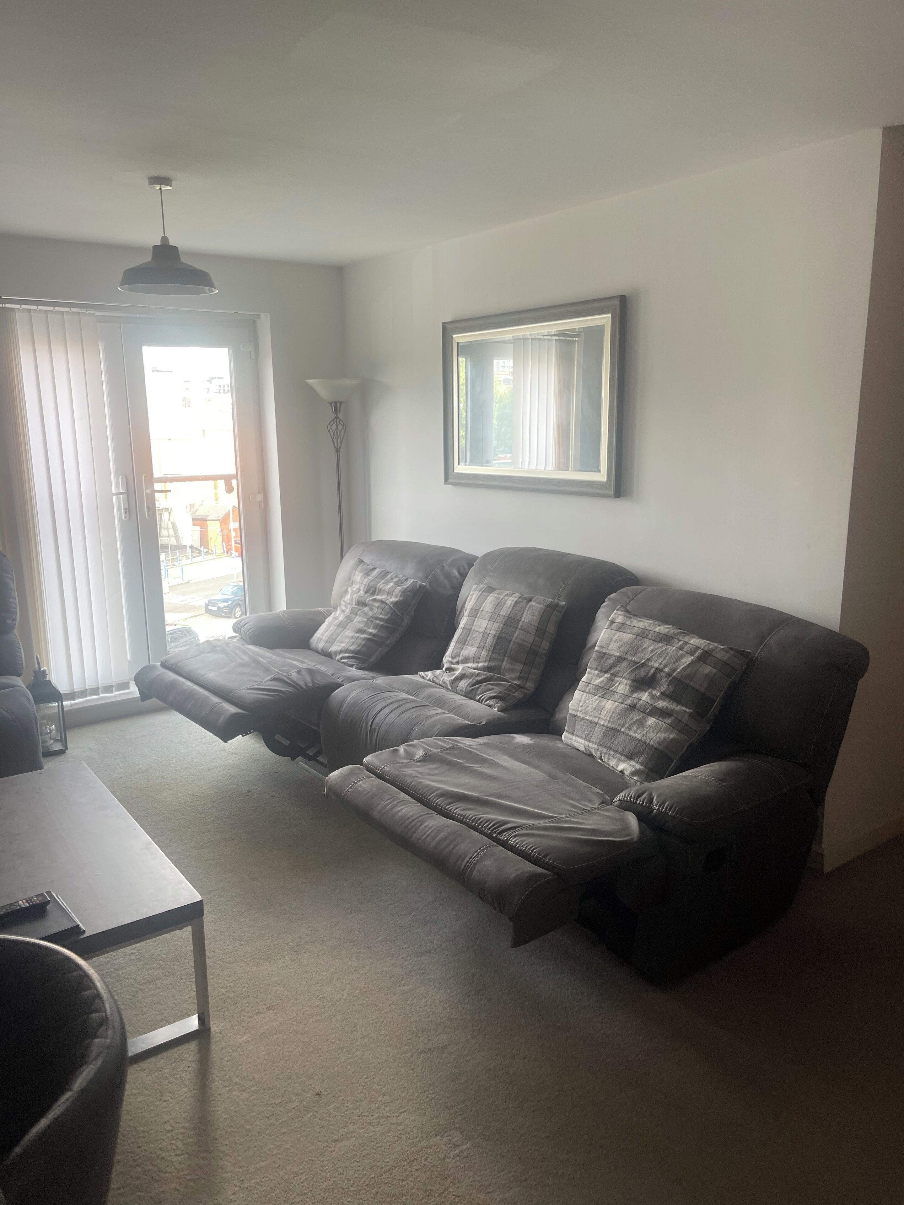 A living room with a sofa, a table, and a floor lamp.
