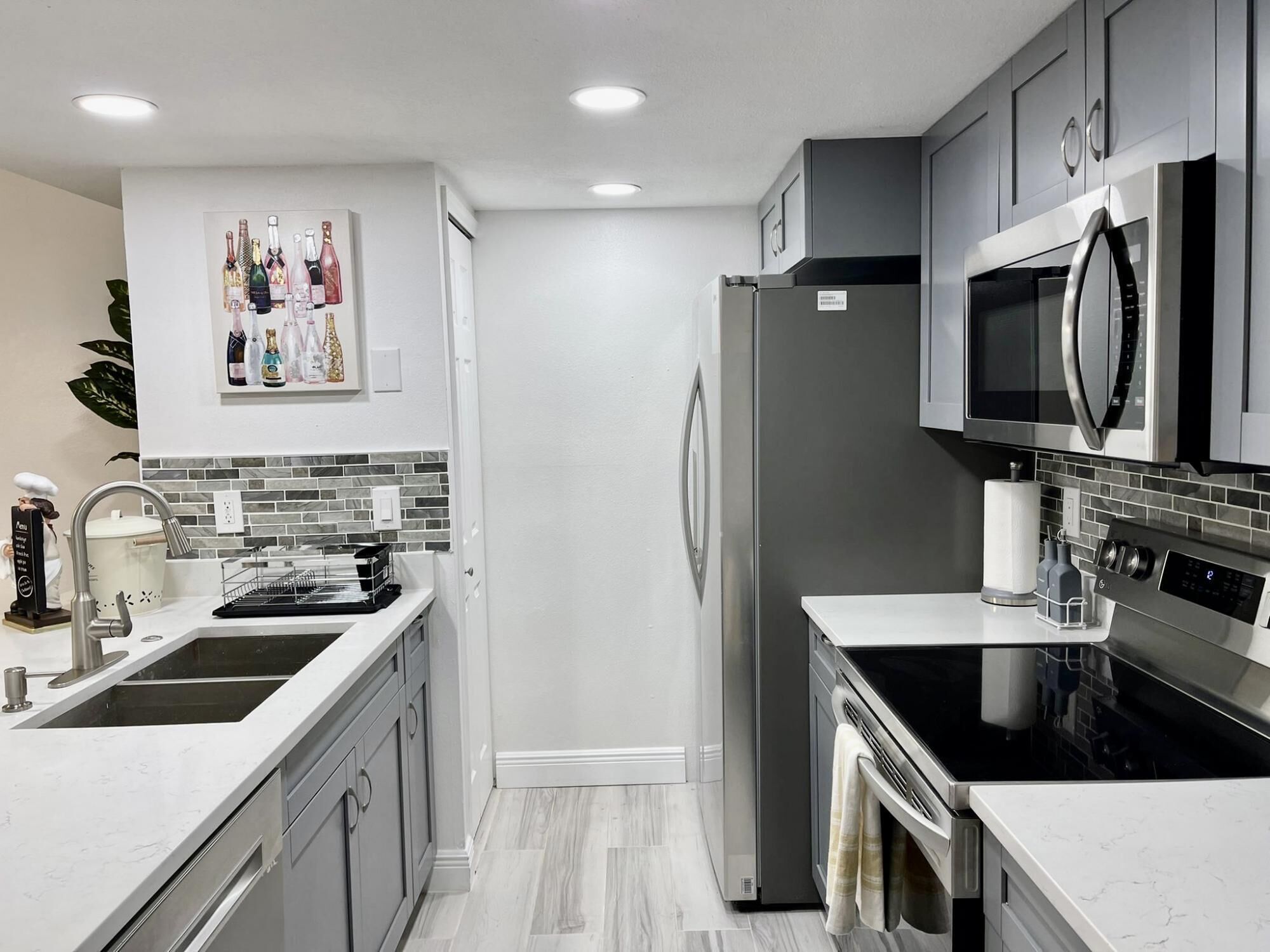 A modern kitchen with stainless steel appliances, a double sink, and a tiled backsplash.