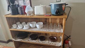 A kitchen counter with various appliances and utensils.