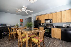 Enjoy meals in the kitchen and dining area, featuring a wooden table and wicker chairs.