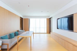 Uma sala de estar moderna com um sofá, uma mesa de centro e uma TV de tela plana fixada na parede.