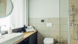 A modern bathroom with a sink, mirror, toilet, and shower. - Harry's Home Zürich Limmattal (Spreitenbach)
