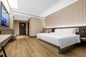 A modern hotel room with a large bed, a desk, a television, and a wooden floor. - Hanting Hotel Changsha Liuyang Yong An (Changsha)