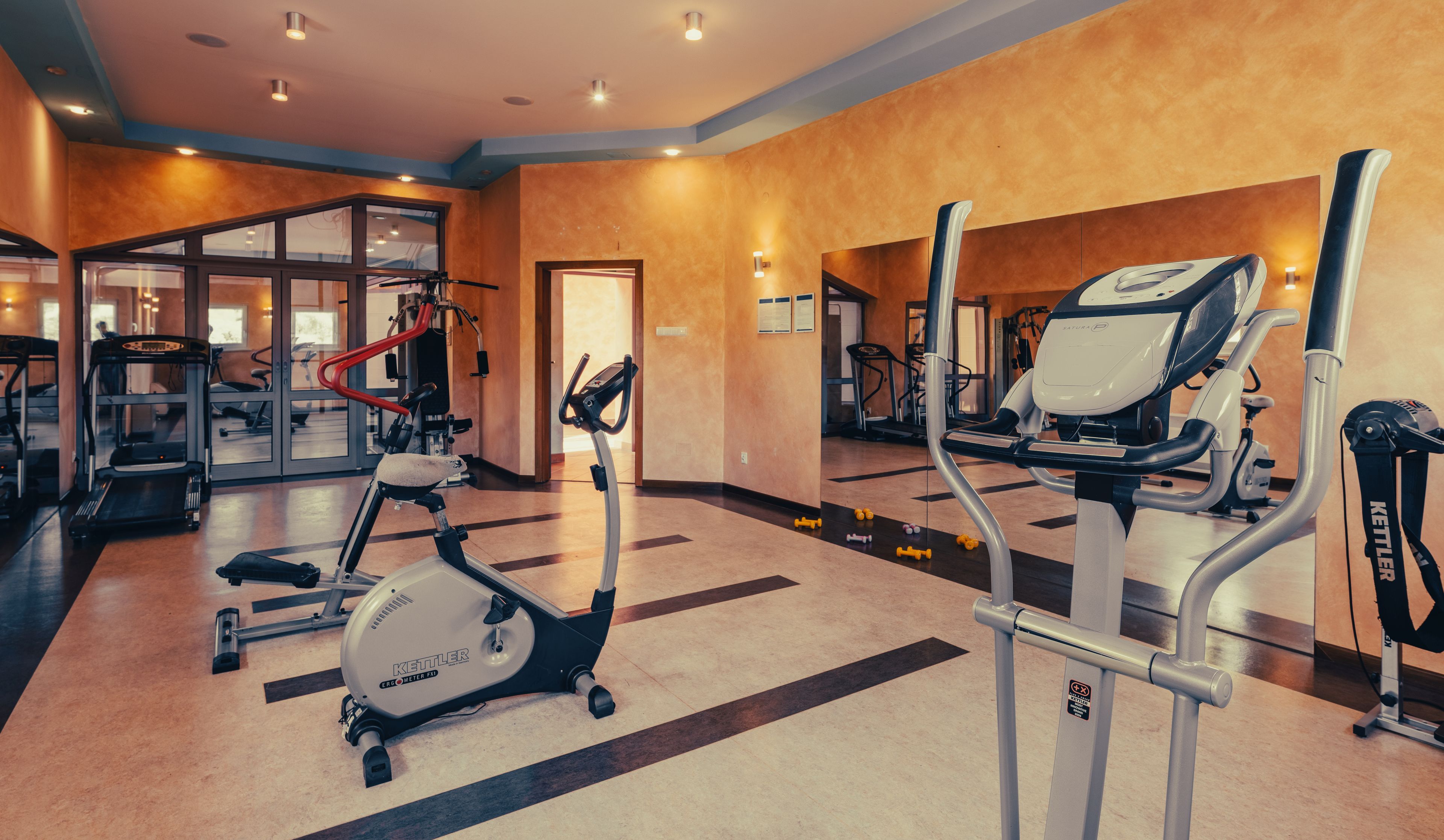 A gym with treadmills, an elliptical, and weight machines.