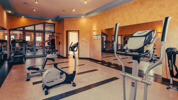 A gym with treadmills, an elliptical, and weight machines.