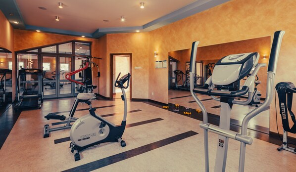 A gym with treadmills, an elliptical, and weight machines. - Hotel Solina Resort & Spa (Solina)