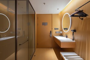 A modern bathroom with a glass shower enclosure, a wooden vanity with a mirror, and a towel rack. - Ji Hotel Qingdao Xinduxin Changsha Road (Qingdao)