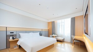 Camera d'albergo moderna con un letto grande, comodini, una scrivania e una sedia.