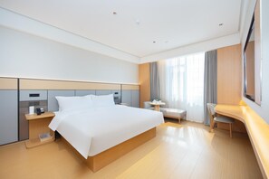 A modern hotel room with a large bed, bedside tables, a desk, and a chair. - Ji Hotel Qingdao Xinduxin Changsha Road (Qingdao)
