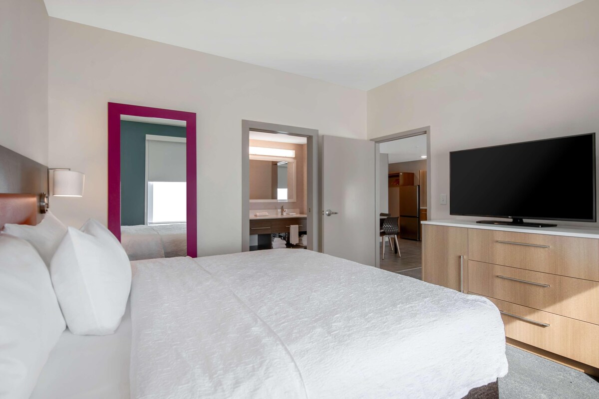 Une chambre d’hôtel équipée d’un lit, d’une télévision, d’une salle de bain et d’une kitchenette.