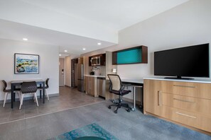 A modern kitchen with a microwave, refrigerator, and a large flat-screen TV. - Home2 Suites By Hilton Savannah I95 North (Port Wentworth)