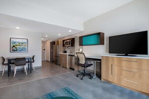 Una cocina moderna con microondas, refrigerador y un televisor de pantalla plana grande.