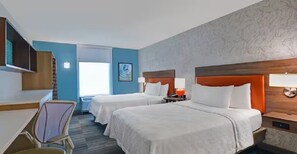 Ein Hotelzimmer mit zwei Betten, einem Schreibtisch und einem Stuhl.