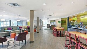 Un espacio interior moderno con áreas de estar, una barra y vistas al exterior.