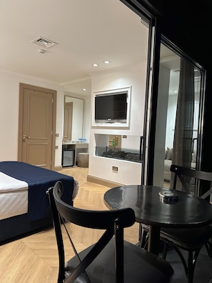 A hotel room with a bed, a dining table, a TV, and a kitchenette. - Taksim Bosphorus Hotel (Istanbul)