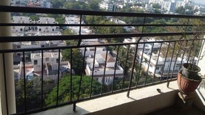 Ein Balkon mit Blick auf eine Wohngegend, inklusive Gebäude und Grünflächen.