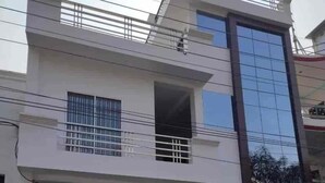 Ein modernes, zweistöckiges Gebäude mit Balkon und großen Fenstern.