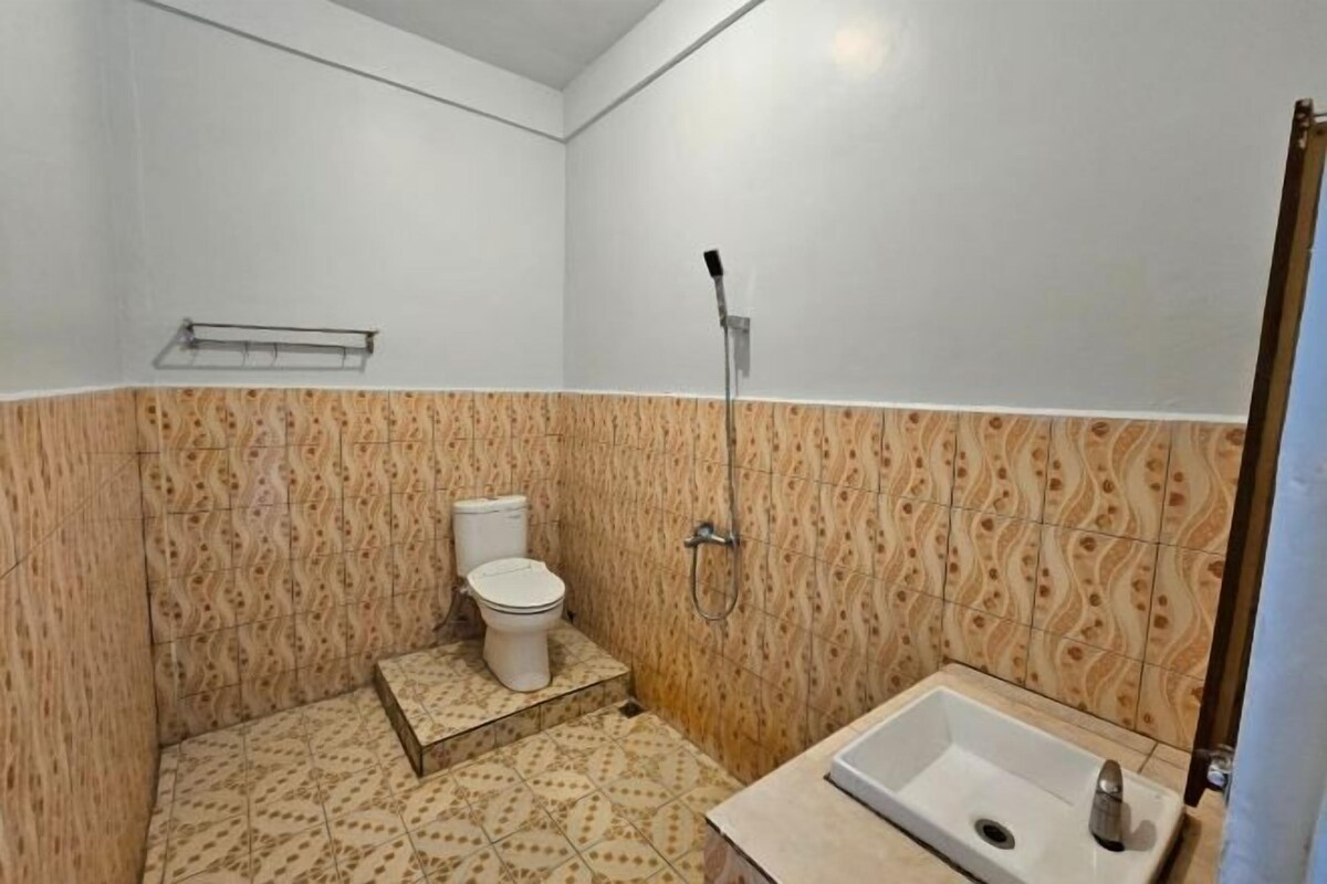 A small bathroom with a toilet, shower, and sink.