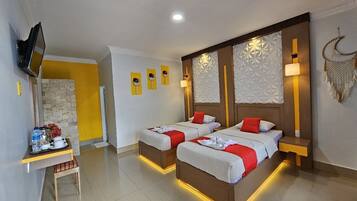 A hotel room with two beds, a TV, a small table with a tray of breakfast items, and decorative wall panels.