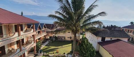 A resort with multiple buildings, a central courtyard, and a palm tree.