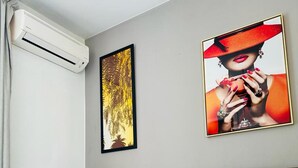 A hotel room with a bed, an air conditioning unit, and two framed artworks on the wall. - Studio Relax Manganao, Proche de la plage et accès a la piscine (Saint-François)