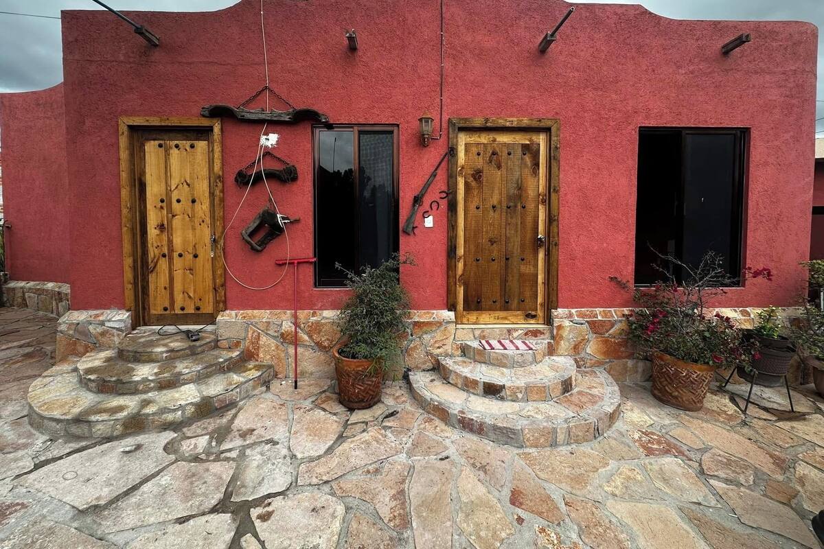 A red building with two wooden doors and windows.