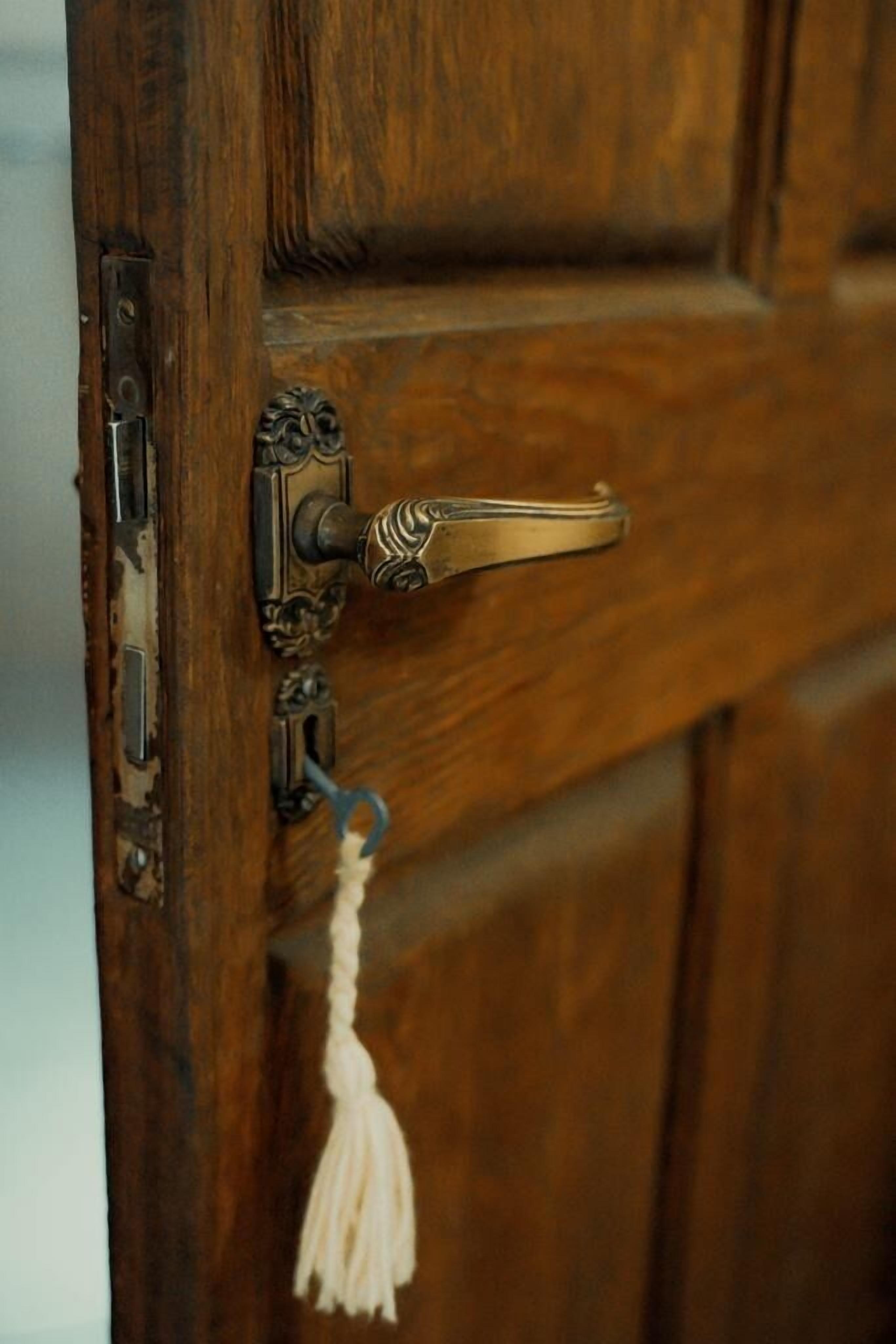 A wooden door with a brass handle and a keyhole.
