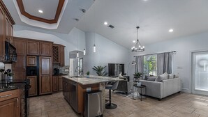 Una cucina moderna con mobili in legno, un'isola centrale ed elettrodomestici in acciaio inossidabile.