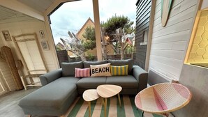 A cozy living area with a grey sectional sofa, a small round table, and a wicker chair.
