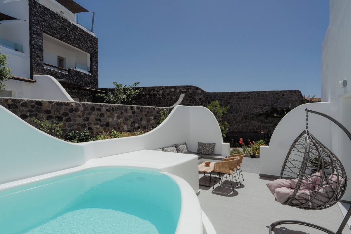 Zona de piscina moderna al aire libre con una silla colgante y asientos.