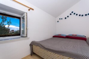 Une chambre à coucher avec un lit, une fenêtre et un élément décoratif fixé au mur.