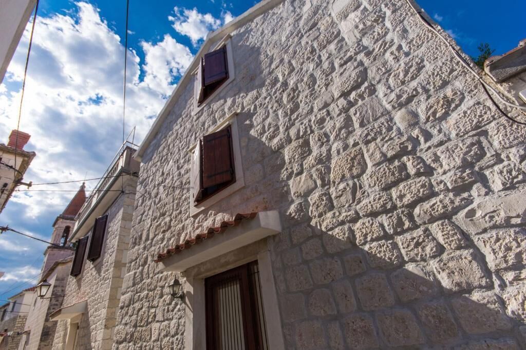 A stone building with a traditional architectural style, featuring a small window and a door.