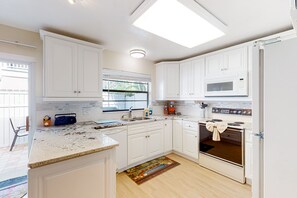 Enjoy cooking in this well-lit kitchen with a large island, double oven, and window overlooking the backyard.