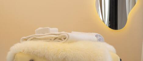 A neatly arranged bathroom with a towel rack, a mirror, and a wall-mounted light fixture.